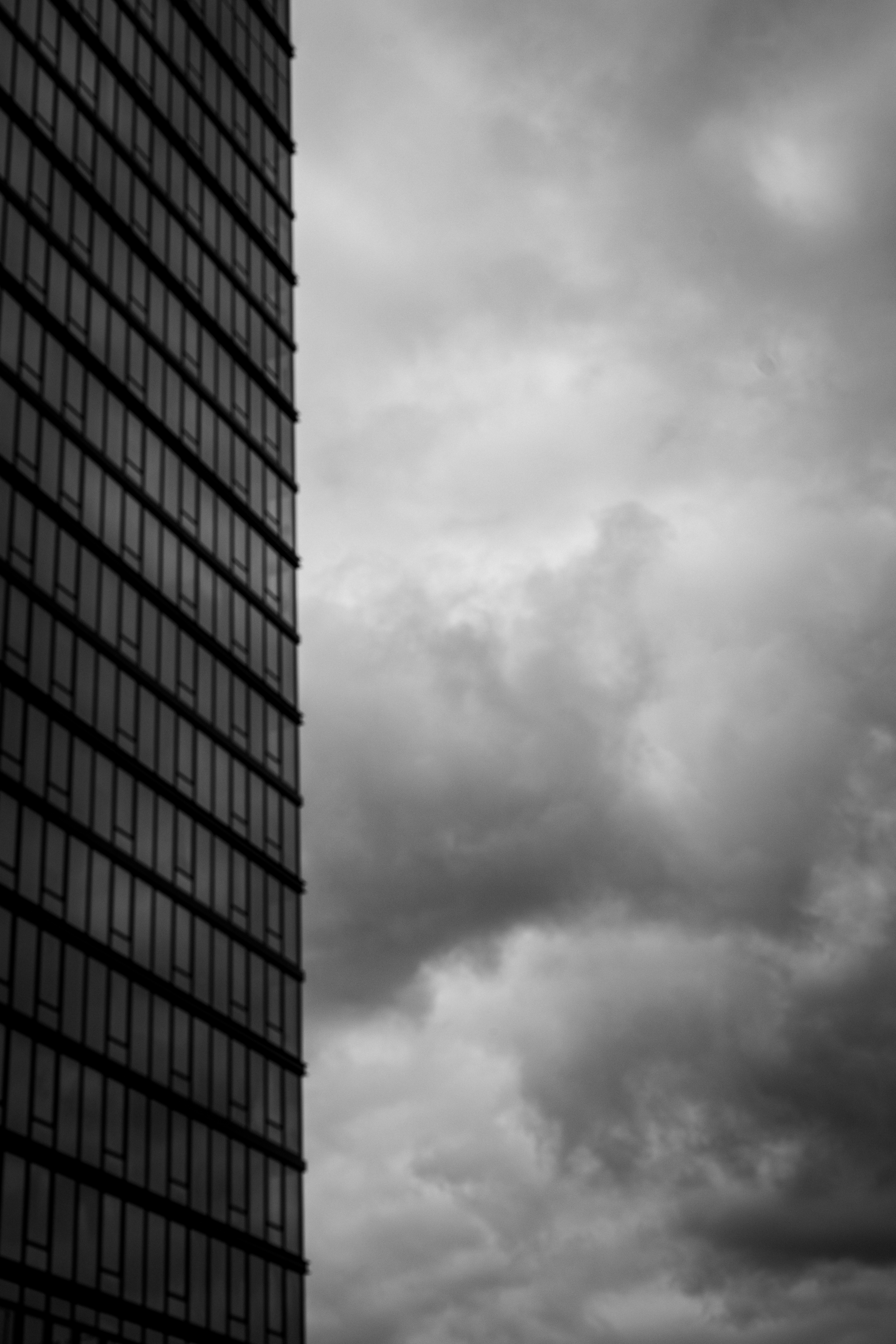 Skyscraper against stormy clouds, B&W